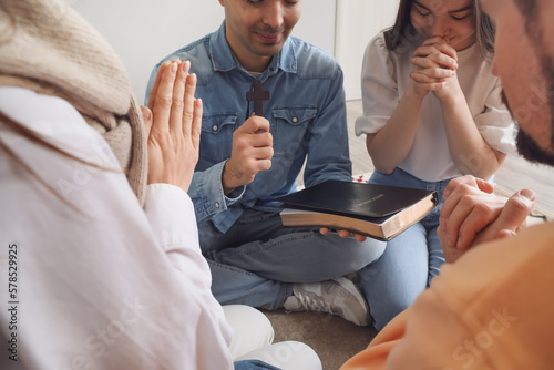 Group of people praying wit...