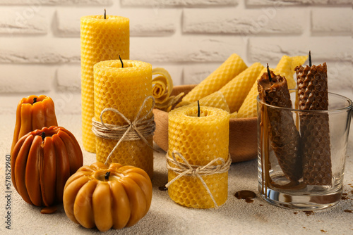Beautiful different beeswax candles on light textured table
