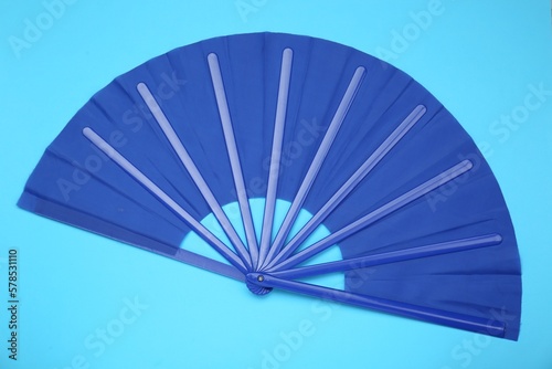 Bright color hand fan on light blue background  top view