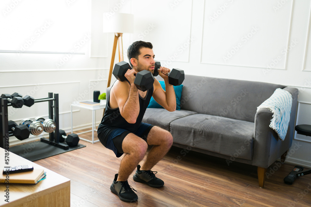 Sporty man using weights during his home workout Stock Photo | Adobe Stock