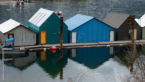 close up reflection of boat houses in Kaslo British Columbia on calm spring day colorful buildings or structures on Kootenay lake geometric shapes and brightly colored boat houses BC travel background photo
