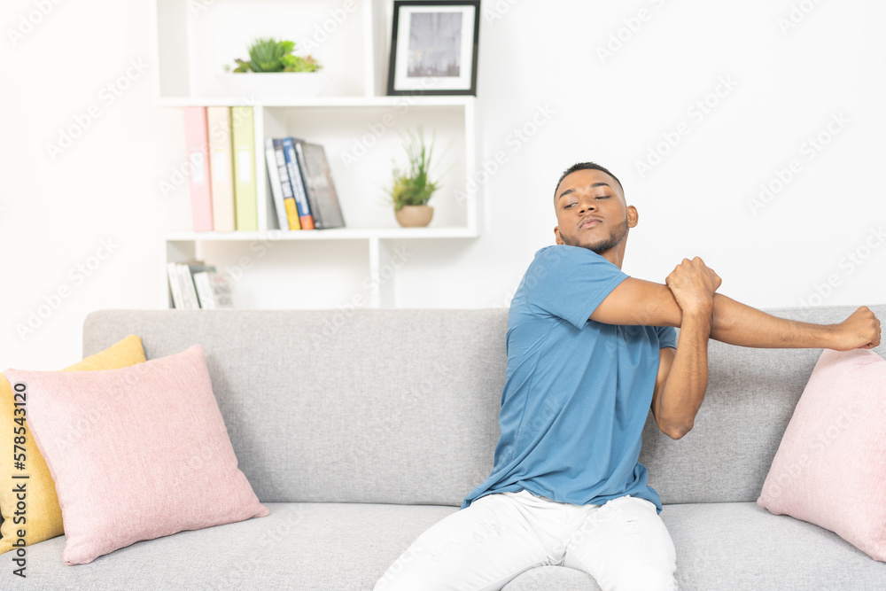 Young man, stretching his arms after many hours of work meetings Young man, stretching his arms after many hours of work meetings