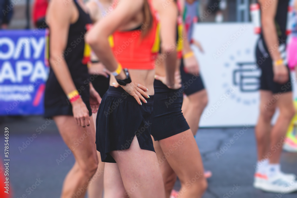 Marathon runners crowd, participants start running the half-marathon in the city streets, crowd of joggers in motion, group athletes outdoor training competition in the rain