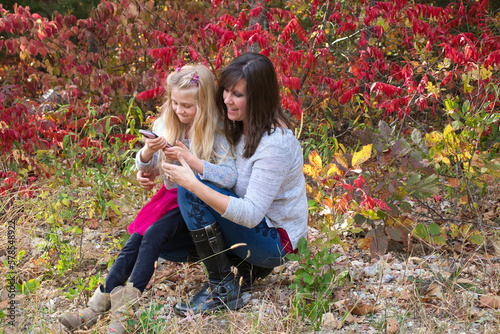 mother and daughter looking at a mobile cell phone