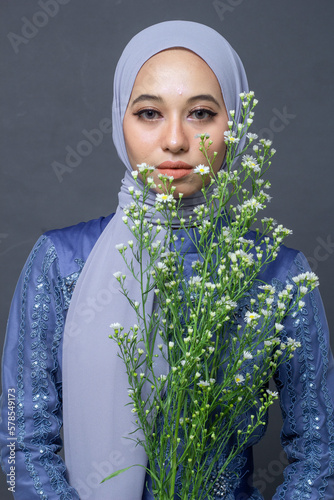 A beauty hijab model with gray scraft and gown in studio  with gray background photo