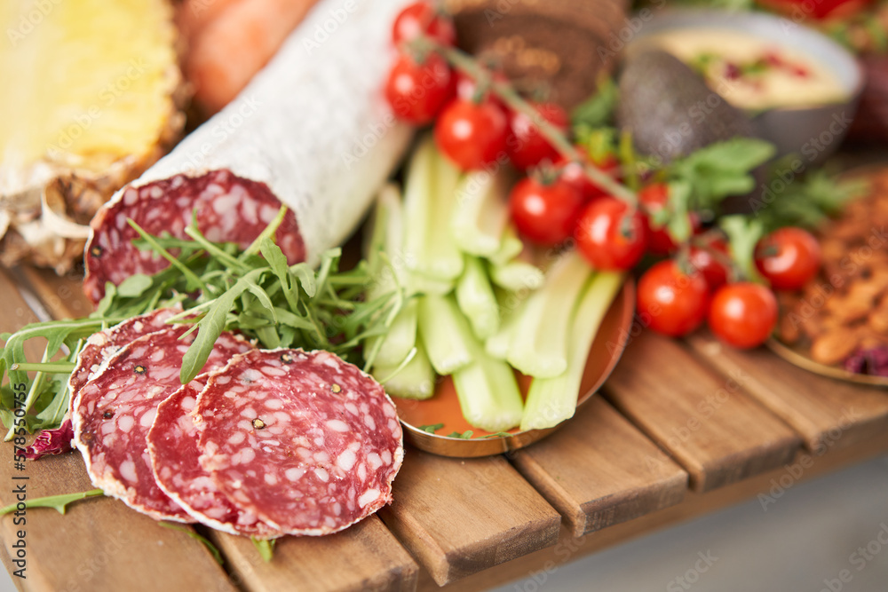 Salami sausage close-up. Table full of mediterranean appetizers, tapas or antipasto. Assorted Italian food set. Delicious snack on party or picnic time. Meat and cheese. Italian style banquet. Salami sausage close-up. Table full of mediterranean appetizers, tapas or antipasto. Assorted Italian food set. Delicious snack on party or picnic time. Meat and cheese. Italian style banquet.