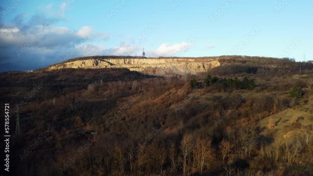 Revealing drone shot of a large quarry with a telecommunications tower on top. Revealing drone shot of a large quarry with a telecommunications tower on top.