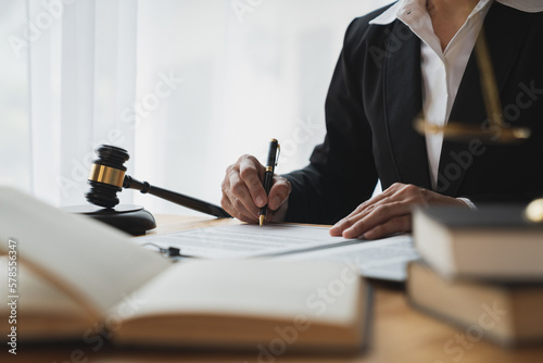 Lawyer, legal adviser, asian businesswoman looking at and writing down contract details business law Study and check the accuracy before signing and clarifying in the office.