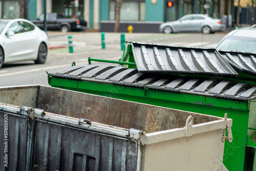 Open dumpsters in a downtown neighborhood restaurant or business or near apartment complex building in empty alleyway © Aaron