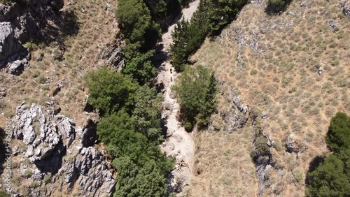 High Angle Aerial View of Hikers Walking in Narrow Trail in Gorge. photo