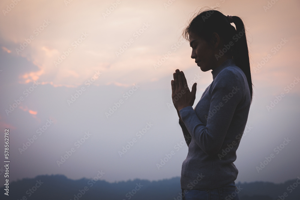 Fototapeta premium woman praying prayers for spiritual faith A prayer to remember God. Faith in religion and belief in God based on blessings. God's help.
