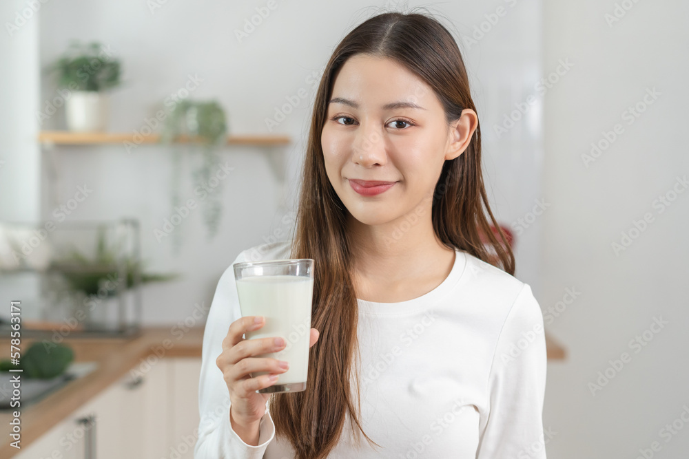 Health care, pretty asian young woman, girl drinking a glass of white fresh, dairy milk for calcium, vitamin wholesome good nutrition in morning at kitchen home. lifestyle, product healthy people. Health care, pretty asian young woman, girl drinking a glass of white fresh, dairy milk for calcium, vitamin wholesome good nutrition in morning at kitchen home. lifestyle, product healthy people.