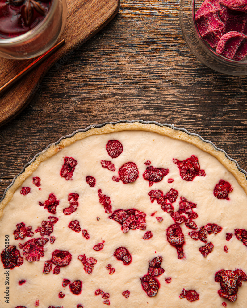 Closeup on raw uncooked raspberry pie on the wooden table Closeup on raw uncooked raspberry pie on the wooden table