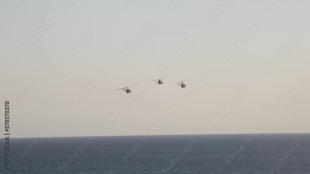 toma amplia desde lejos de helicopteros en espectaculo aereo con el fondo del mar. toma amplia desde lejos de helicopteros en espectaculo aereo con el fondo del mar.