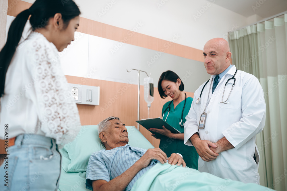professional doctor standing by explain the treatment information via male elderly patient lying in bed in private hospital sickroom. The treatment program is suitable for people to socialize elderly professional doctor standing by explain the treatment information via male elderly patient lying in bed in private hospital sickroom. The treatment program is suitable for people to socialize elderly