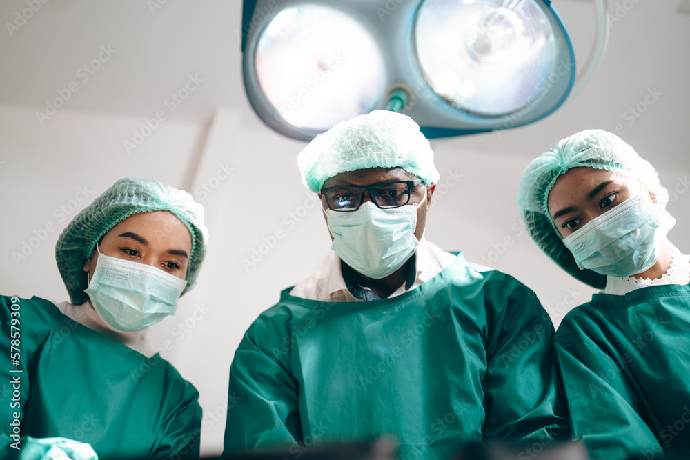 Group of concentrated surgeons team engaging in rescue of male patient in hospital operation room, emergency case of surgery medical technology, health care and disease treatment concept Group of concentrated surgeons team engaging in rescue of male patient in hospital operation room, emergency case of surgery medical technology, health care and disease treatment concept