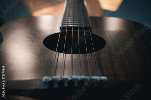 Close-up of acoustic guitar. Guitar in dark shades. detail of classic guitar with shallow depth of field.