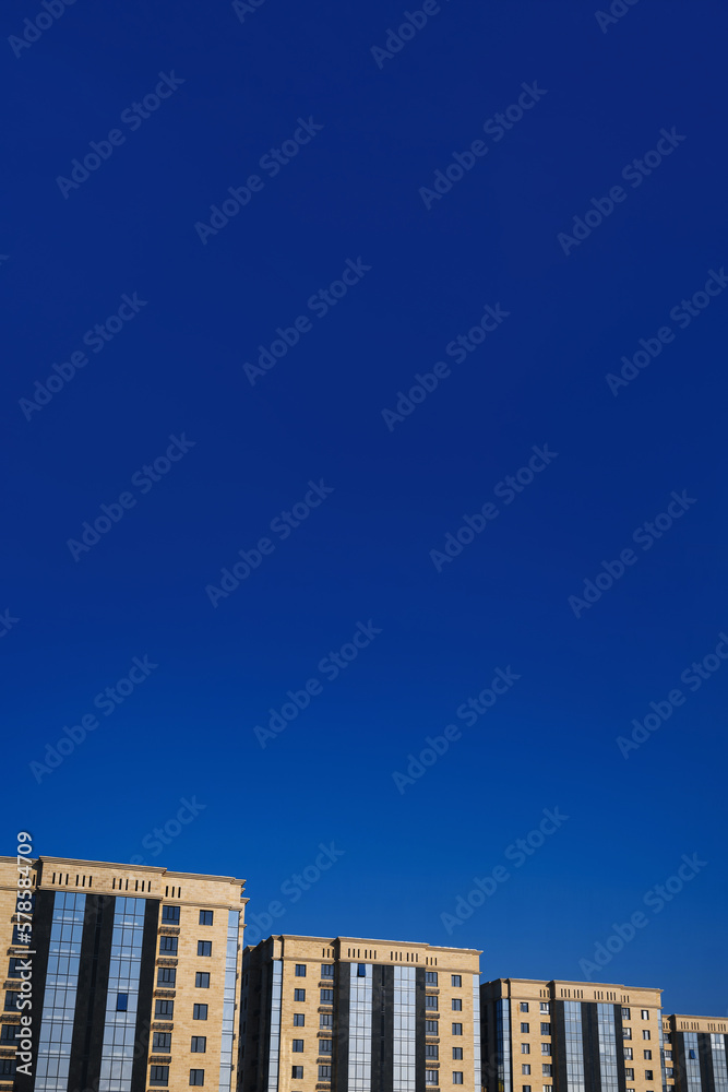 residential new luxury houses with windows and balconies on a blue sky background