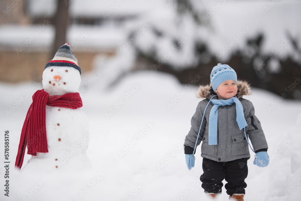 Snowman and boy outdoors. Freedom childhood leisure activities