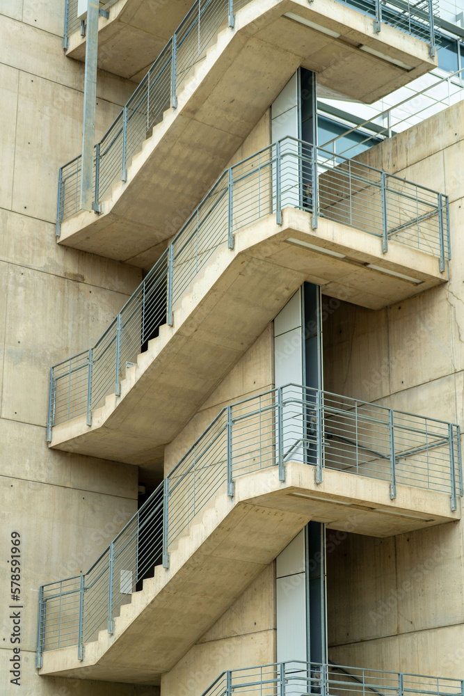 Fototapeta premium Spiral cement staircase in industrial area of commercial districts in downtown city neighborhoods with metal hand rails