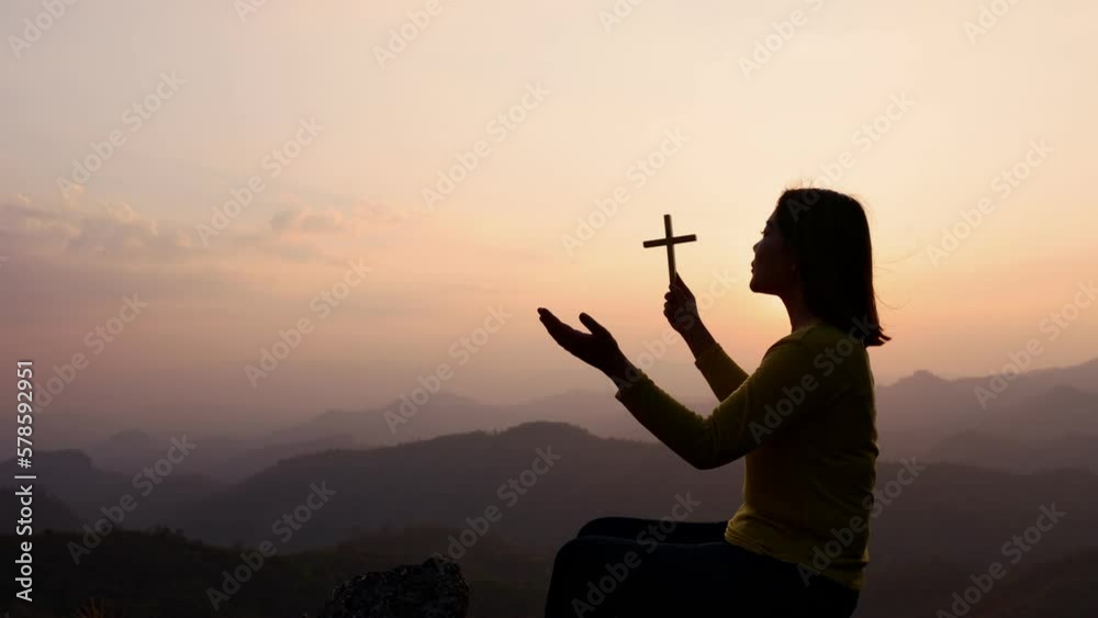 Silhouette of woman hands praying with cross in nature sunrise ...