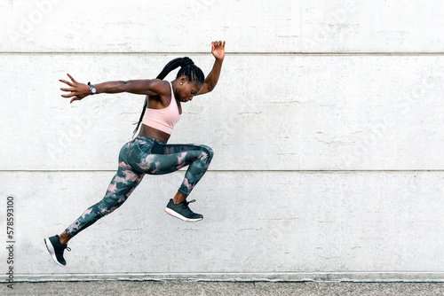 African-American athlete sprinter jumping. Sport