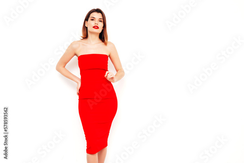 Young beautiful smiling female in trendy summer red evening dress. Sexy carefree brunette woman posing in studio, isolated on white. Positive model with evening makeup. Cheerful and happy. red lips