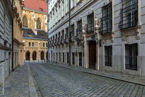 Narrow cobblestone street among historic buildings in historic center of Vienna.