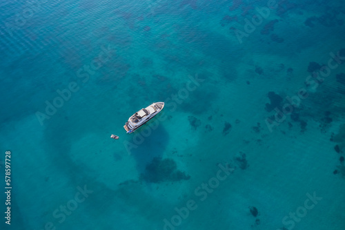 white yacht anchored on clear water aerial view. © Berg