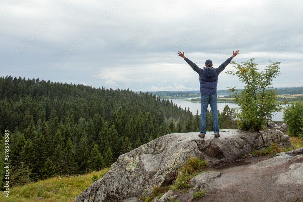 Man looking at the beautiful view with arms outstretched on mountain top