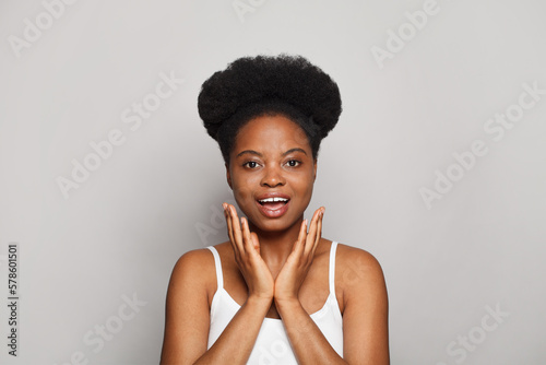 Happy excited cheerful surprised brunette model woman looking at camera against white studio wall banner background