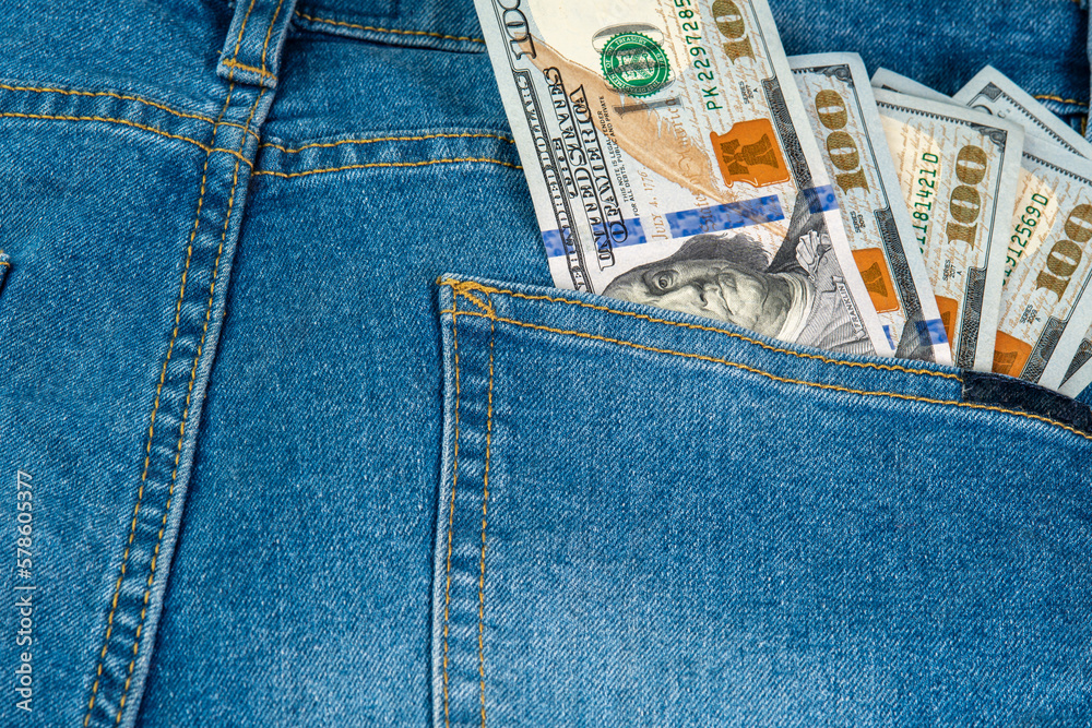 Us dollars in back pocket of denim jeans. Denim background for design