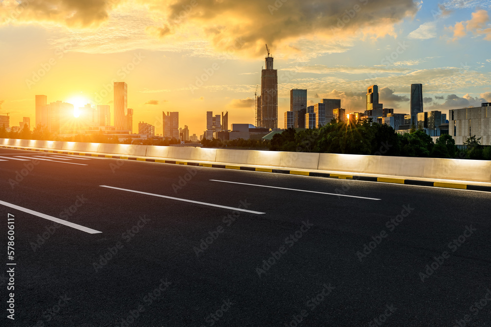 Asphalt road and city skyline with modern buildings at sunset in Ningbo, Zhejiang Province, China.
