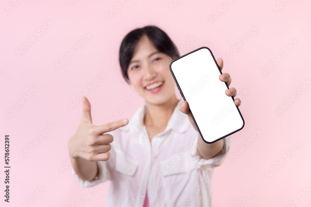 happy smiling young asian woman recommending showing new application or mobile advertisement, mockup smartphone template banner isolated on pink background. Collage blank screen digital mobile device. happy smiling young asian woman recommending showing new application or mobile advertisement, mockup smartphone template banner isolated on pink background. Collage blank screen digital mobile device.