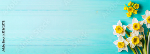 Spring easter background with top view of daffodils bouquet on light blue wooden table with copy space