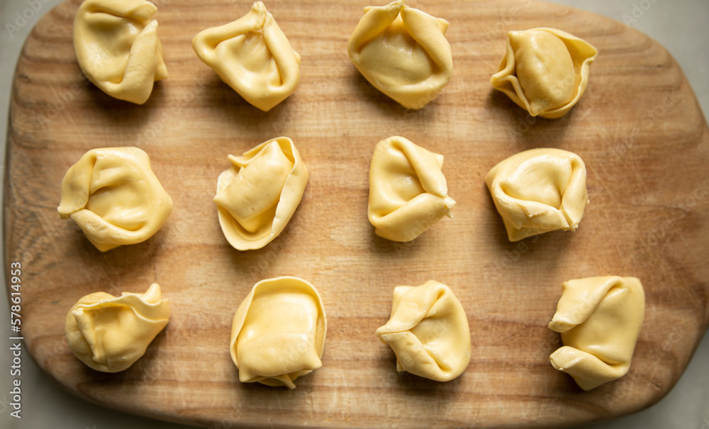 uncooked ravioli on a wooden cutting board close up top view. raw dumplings on a wooden board uncooked ravioli on a wooden cutting board close up top view. raw dumplings on a wooden board