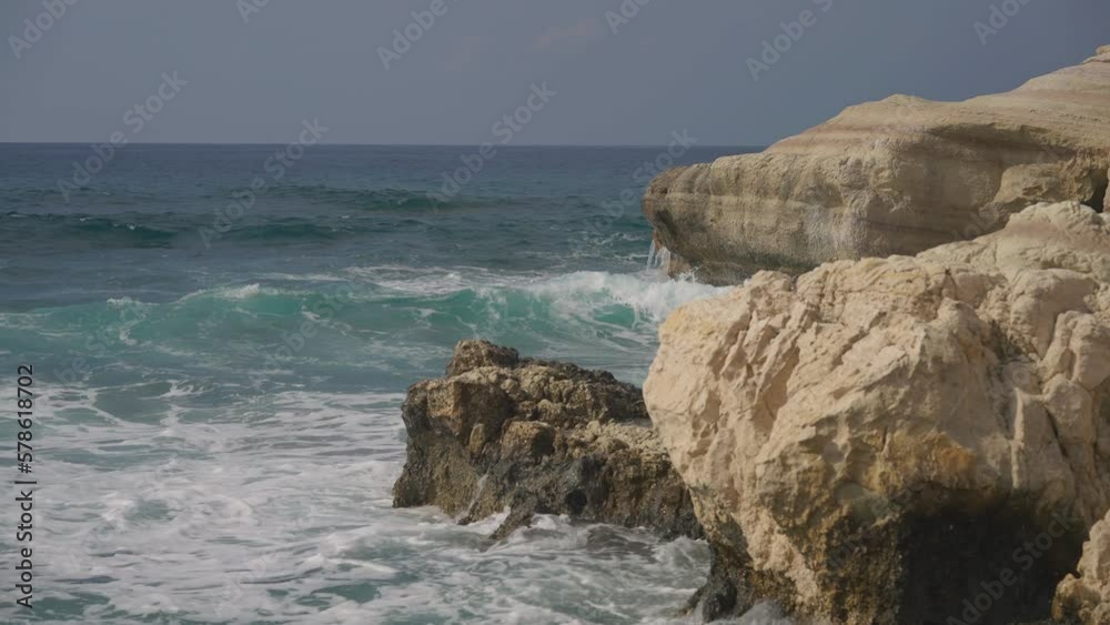 Mediterranean sea water splashing on rocks at coast. Foamy ocean waves rolling outdoors to beach Mediterranean sea water splashing on rocks at coast. Foamy ocean waves rolling outdoors to beach