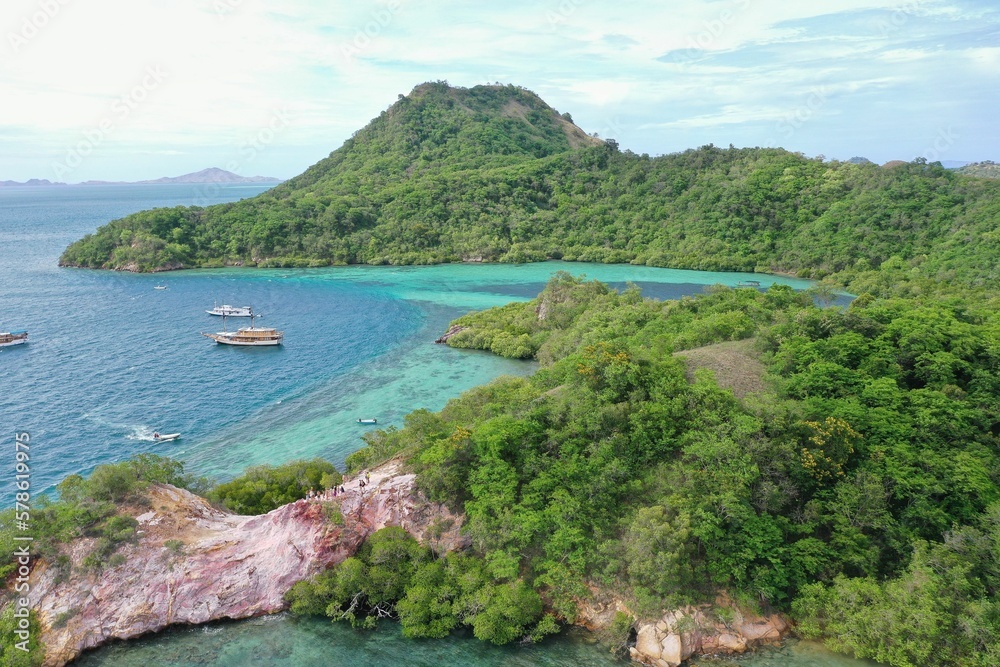 Idyllic panorama of a bay in Komodo National Park on Flores with turquoise sea with boats and green hills. Idyllic panorama of a bay in Komodo National Park on Flores with turquoise sea with boats and green hills.