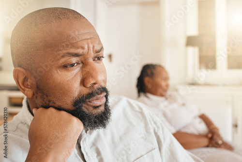 Face, frustrated or argument and a black man looking angry or upset while thinking about a fight with his wife in their home. Divorce, idea and fighting with a senior couple sitting in a living room
