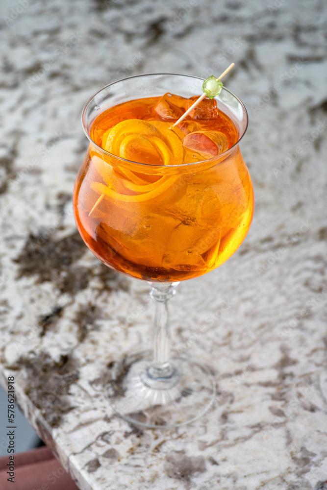 Aperol is an alcoholic cocktail. Orange. Cold drink with ice cubes. The glass is on the bar.