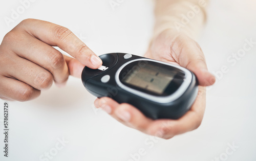 Diabetes, blood test and medical with finger of woman for insulin level, monitoring and glucose check. Medicine, healthcare and digital with hands of patient and glucometer machine for sugar balance