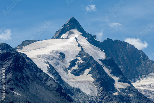 Mountain peak with a melting glacier on brown and grey rocks in an alpine area © Uwe