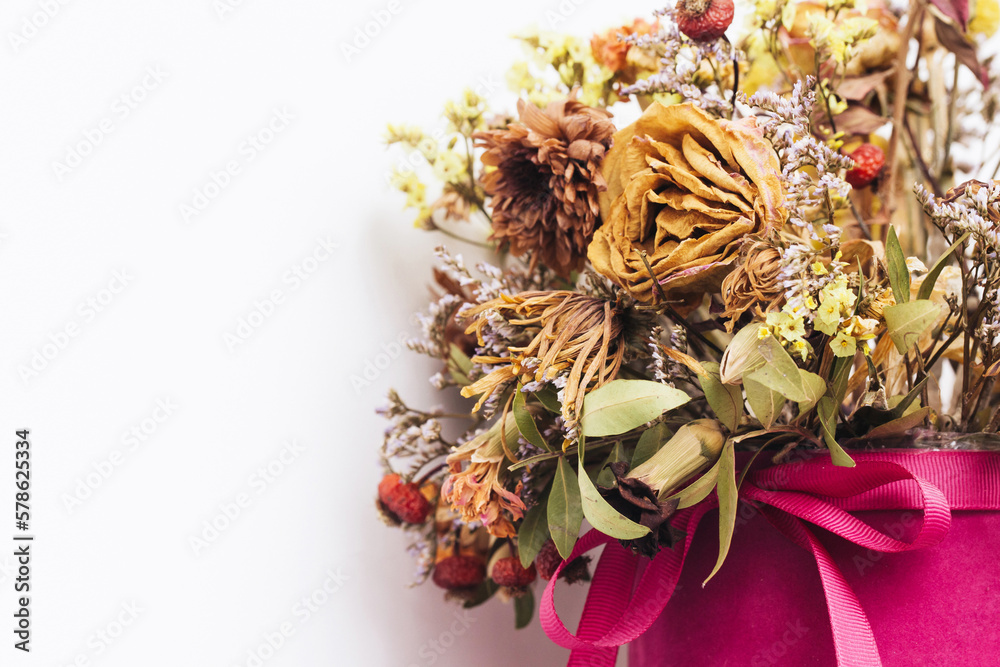 Flowers in a box. Dry flowers bouquet. Warm color flowers. Dried rose background. Aristic autumn floral texture. Beautiful shallow depth of field dry flower composition. Decoration on home wall.