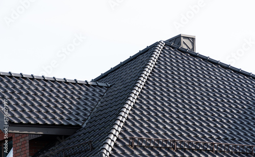 Dark brown metal roof tiles. The roof of corrugated sheet