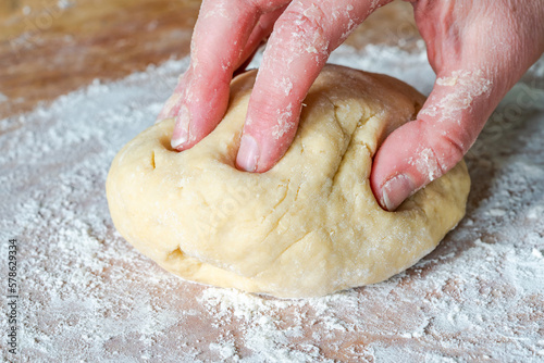 Woman's hand knead raw dough