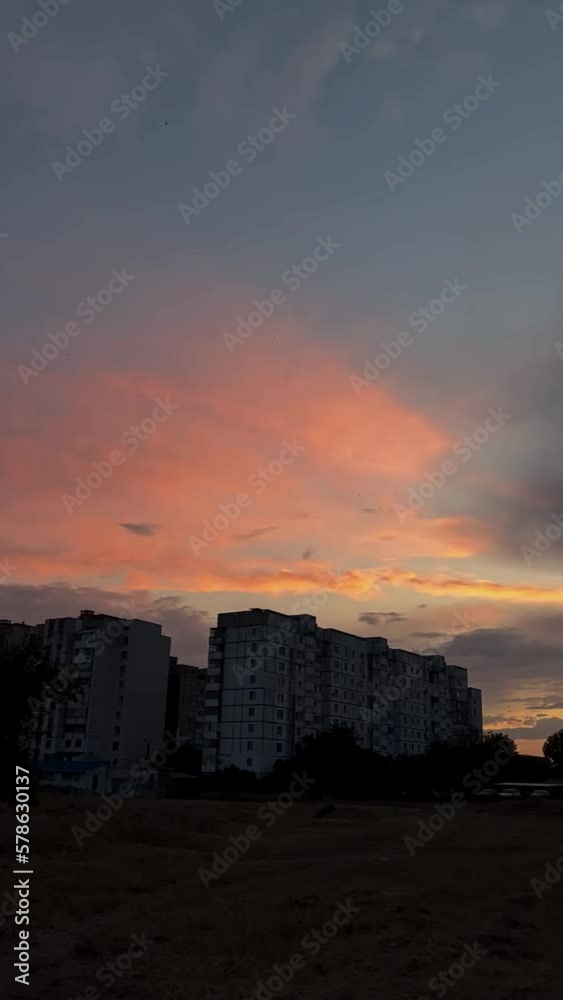 Dramatic multicolored cloudy sky above dark silhouettes of city buildings. Dramatic multicolored cloudy sky above dark silhouettes of city buildings.