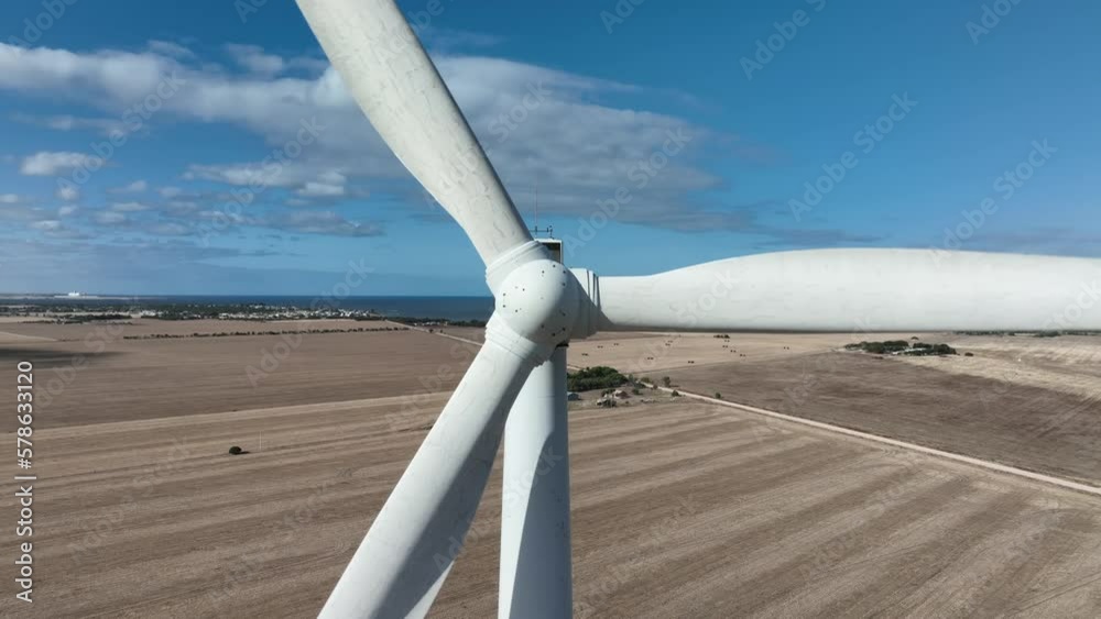 Very close orbiting shot of wind turbines spinning. Camera starting close and flying backwards while looking directly at Turbine centre. Shot on Wind Farm in South Australia. Very close orbiting shot of wind turbines spinning. Camera starting close and flying backwards while looking directly at Turbine centre. Shot on Wind Farm in South Australia.