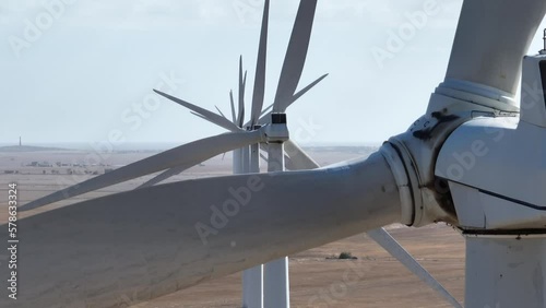 Stationary shot of Wind Turbines shot on telephoto zoom lens. A seemingly infinite line of wind turbines spinning in the distance Shot on a large wind farm in South Australia photo