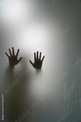 Left and right hand shadow blur behind frosted glass.shadow of hands behind frosted glass