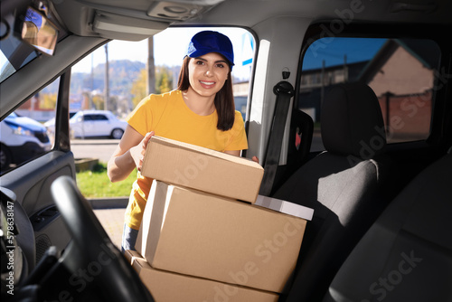 Courier taking parcel from car. Delivery service